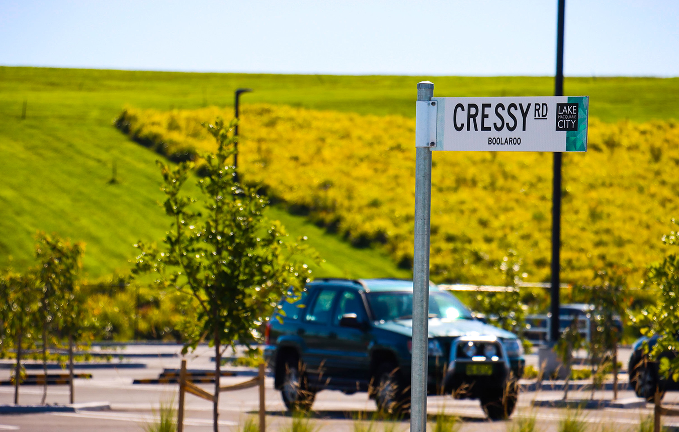 Cressy Road street sign with car in background and green grass