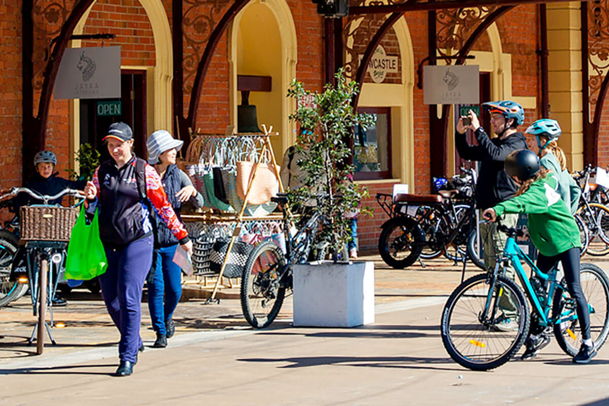 People walking and riding through The Station, Newcastle. Credit: Hunter and Central Coast Development Corporation